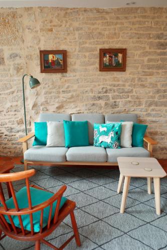 a living room with a couch and a chair at The Little Hideaway - La Petite Maison Cachée in Noyers