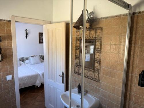a bathroom with a shower and a sink and a bed at El Rancho in Tarifa