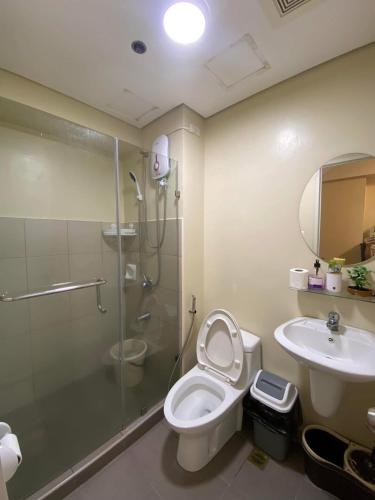 a bathroom with a shower and a toilet and a sink at Avida Tower 2 in Davao City