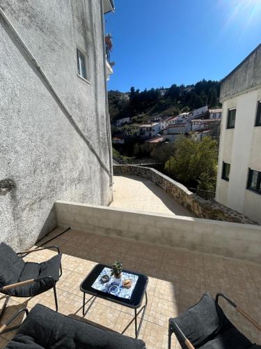 a patio with chairs and a table on a building at Encanto do Rio in Bragança