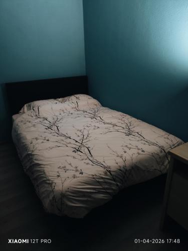 a bed in a blue room with a blanket on it at Casa 28 in Kapelle-op-den-Bos