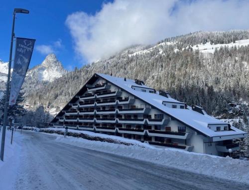 a large building with snow on it next to a road at Studio, proche des pistes et des commerces in Vionnaz