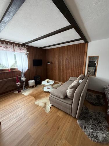 a living room with a couch and a table at Studio, proche des pistes et des commerces in Vionnaz