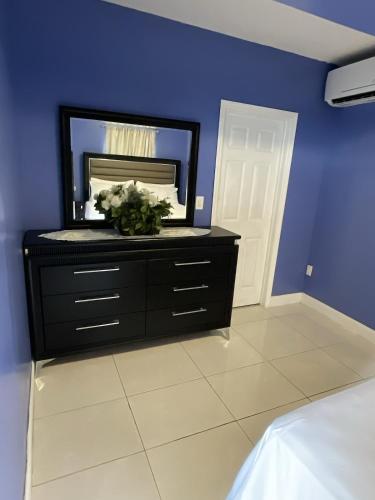 a bedroom with a black dresser with a mirror at Sweet Escape Cozy Studio in Fort Lauderdale