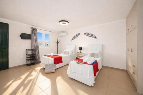 two beds in a room with white walls at Villa Sequoia Yellow in Barbati