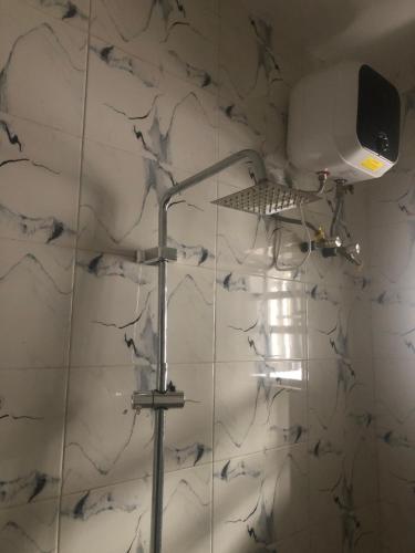 a shower with a lamp on a white wall at The 7th Haven in Uyo