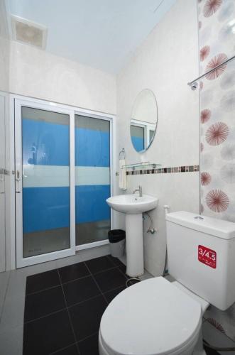 a bathroom with a toilet and a sink and a mirror at โรงแรมสตูลธานี satun tanee hotel in Satun
