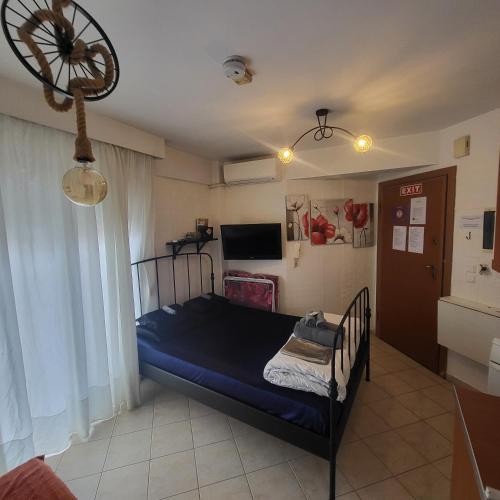 a bedroom with a blue bed and a television at Konstantinos's Luxury Studio in Thessaloniki