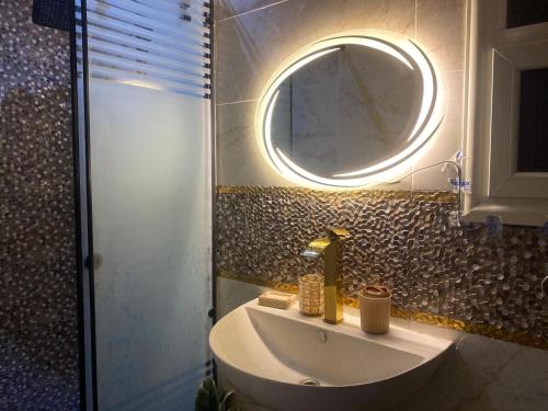 a bathroom with a sink and a round mirror at Nile residence in Al Kawāmil Qiblī