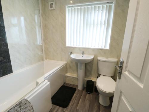 a bathroom with a toilet and a sink at Min Y Cae in Cemaes Bay