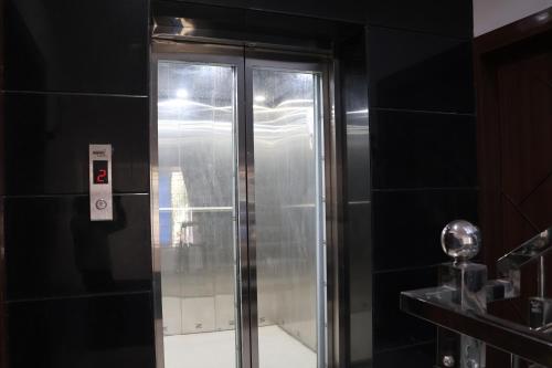 a shower in a bathroom with a glass door at Nice View Hotel in Gopālganj