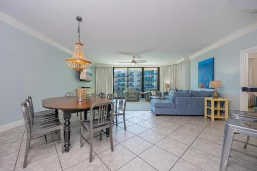 a dining room and living room with a table and chairs at Phoenix on the Bay 1326 condo in Orange Beach