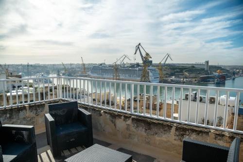 a balcony with chairs and a view of a harbor at Senglea Charming 2BDR Townhouse in Senglea