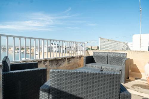 a balcony with two chairs and a table and chairs at Senglea Charming 2BDR Townhouse in Senglea