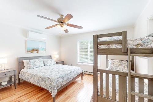 a bedroom with two bunk beds and a ceiling fan at Nubble's Perch in York