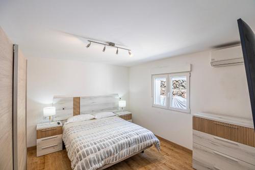 a white bedroom with a bed and a window at Villa Las Norias in Tazacorte