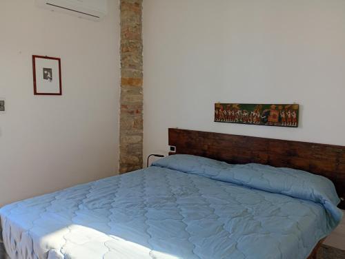 a bedroom with a bed with a wooden headboard at Casa Del Colle in Casasco