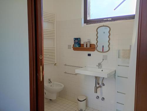 a bathroom with a sink and a toilet at Casa Del Colle in Casasco