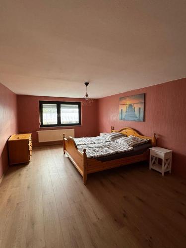 a bedroom with a bed in a room with pink walls at Ferienhaus am Rad- und Wanderweg in Nerdlen