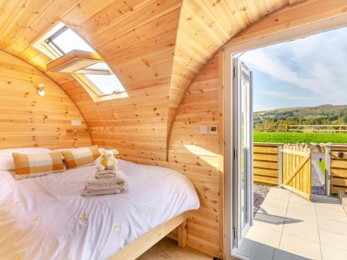 a log cabin bedroom with a bed and a large window at 1 Bed in Conwy oc-95222 in Conwy