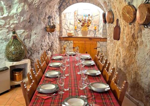 a long table with plates and wine glasses on it at La grotta di NiMa in Pretoro