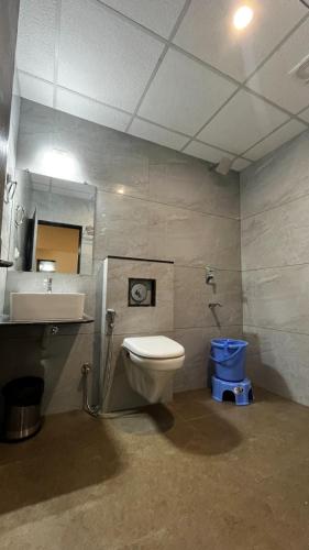 a bathroom with a toilet and a sink at Rangoli Suites & Restrobar in Bantvāl