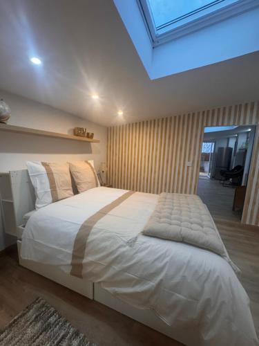 a large white bed in a bedroom with a skylight at Eaunes au Soleil in Eaunes