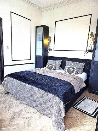 a bedroom with a large bed with a blue blanket at Midcoast Wohnung „THE BLACK“ in Nortorf