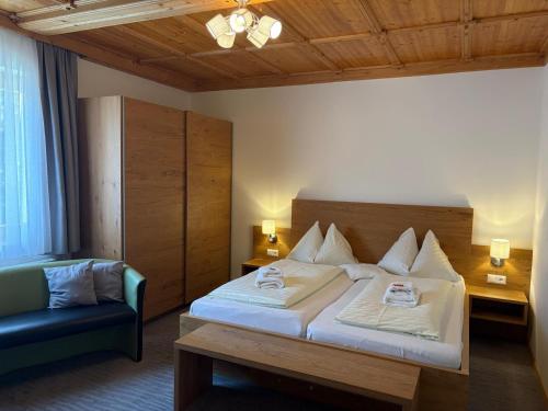 a hotel room with a bed and a chair at Pension Jägerhof in Mallnitz