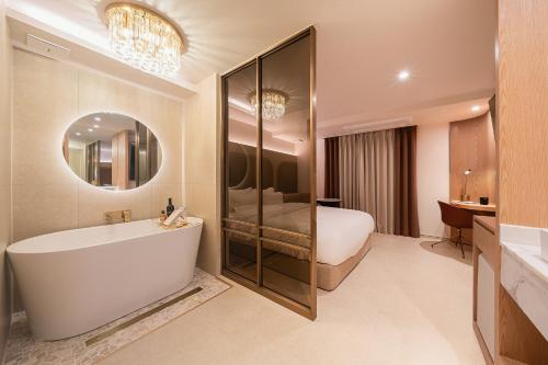 a bathroom with a tub and a bed and a bedroom at 신림 빌라드보니 villa de boni in Seoul