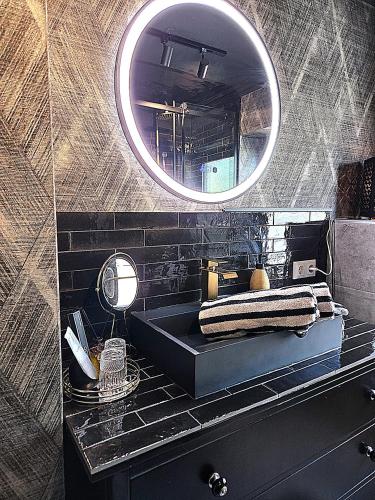 a bathroom with a black sink and a mirror at Midcoast Wohnung „THE BLACK“ in Nortorf