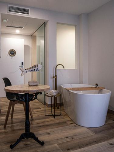 a bathroom with a large tub and a table at A Casa do Tella e Rosalía in Portosin