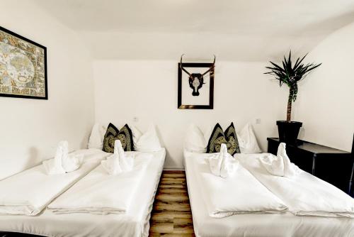 a room with three white beds with pillows at Das Bergnest Maishofen in Maishofen