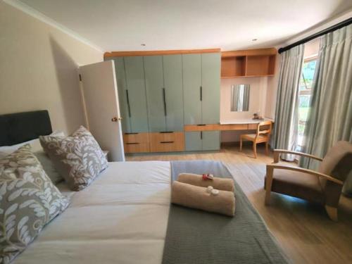 a bedroom with a bed with a chair and a desk at Pearl Vista in Somerset West