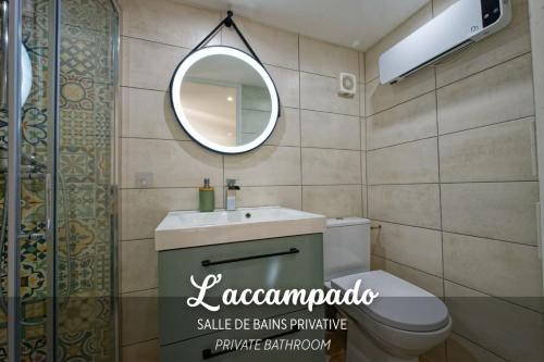 a bathroom with a white toilet and a mirror at L'accampado in Arles