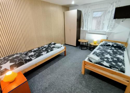 a bedroom with two beds and a tv in it at Villa LIKE "garden-grill" in Bardejov