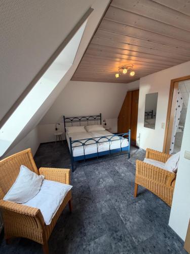 a attic room with two beds and two chairs at Irseer Hof in Hagnau in Hagnau
