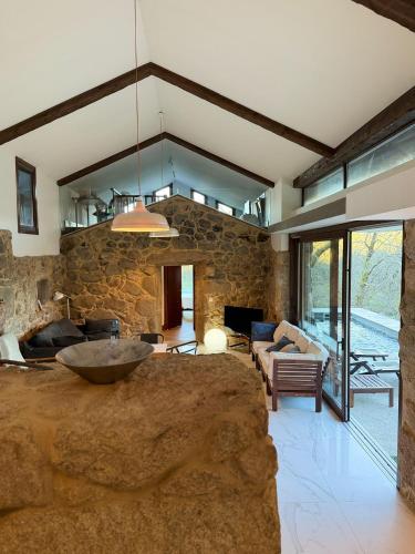 a large living room with a stone wall at Chalet con piscina Gondomar in Gondomar