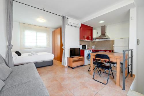 a room with a bed and a kitchen with a table at Hauzify I Apartaments Bellaire in Blanes