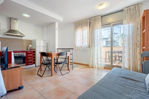a room with a kitchen and a table and a bed at Hauzify I Apartaments Bellaire in Blanes