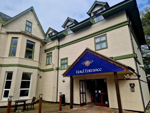 a large building with a blue sign in front of it at Charter Hotel Bournemouth in Bournemouth