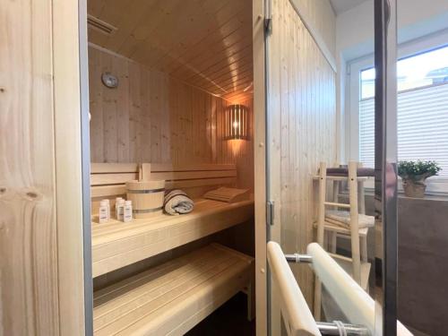 a sauna with wood paneled walls and a wooden floor at Dahmer Strand 1 - LÜTT HUIS in Dahme