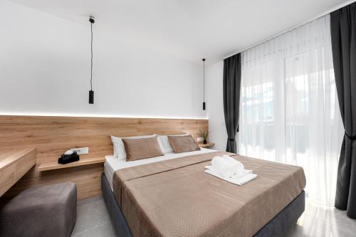 a bedroom with a large bed and a large window at Sunshine Breeze in Promajna