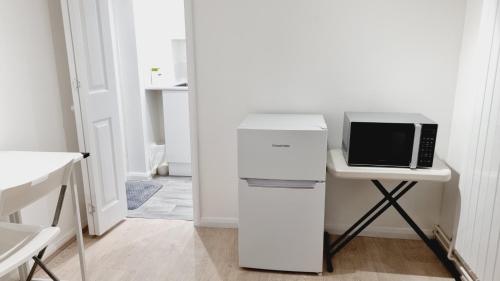 a white refrigerator with a microwave on a desk at Single Room near Science Park in Histon