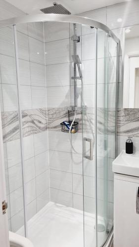 a shower with a glass door in a bathroom at Single Room near Science Park in Histon