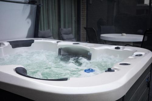 a white bath tub filled with water in a room at Guesthouse Max in Burcht