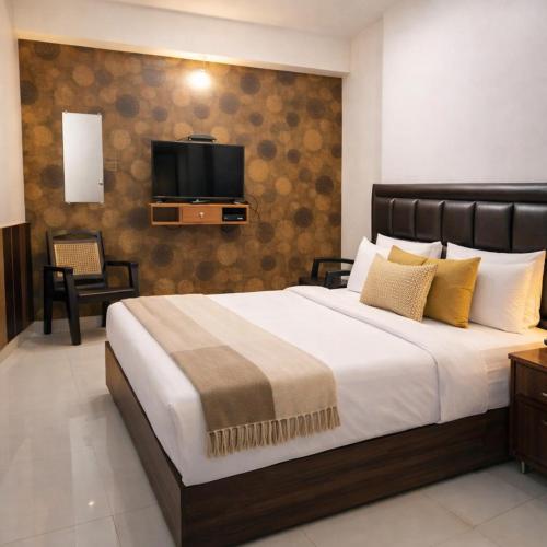 a bedroom with a large bed with a tv on the wall at Absolute hostel in Meerut