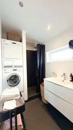 a bathroom with a washing machine and a sink at Penthouse Apartment with Balcony in City Centre and Private Parking in Tórshavn