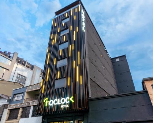 a tall building with a sign on the side of it at Hotel Time Oclock Medellin in Medellín