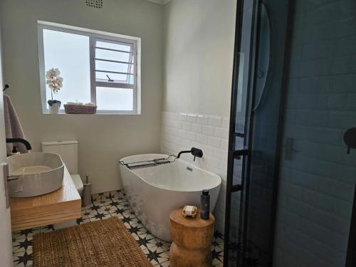 a bathroom with a tub and a sink and a shower at Graatjie in Kleinmond
